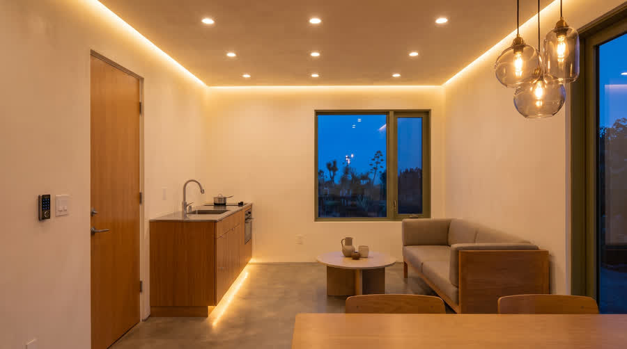 CADU interior showing cove lighting, toe-kick glow and a pendant cluster.